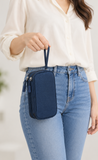 AI-generated lifestyle illustration of a model carrying the Navy Blue double-layer Oxford wristlet organizer