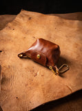 Cognac genuine leather coin purse with visible grain, snap flap and attached clip