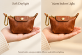 Cognac purse under soft daylight and warm indoor light, held with a cream knit sleeve