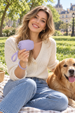 Lavender mini wristlet modeled on green grass beside a golden retriever