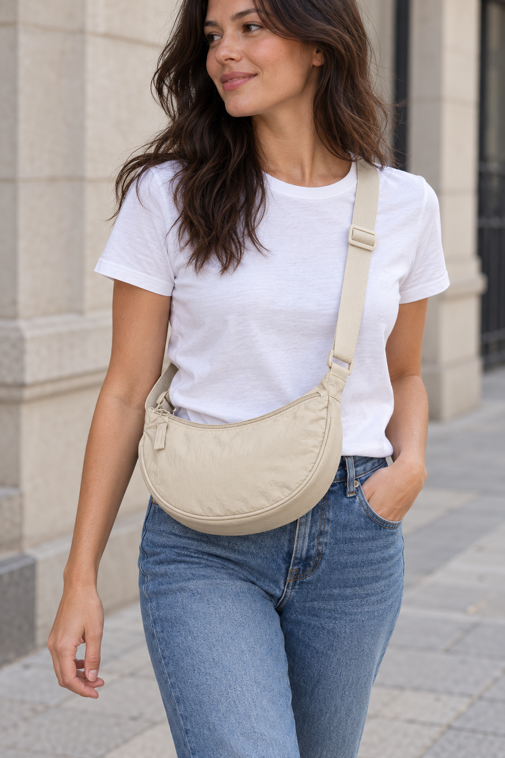 Model wearing the beige crescent bag crossbody